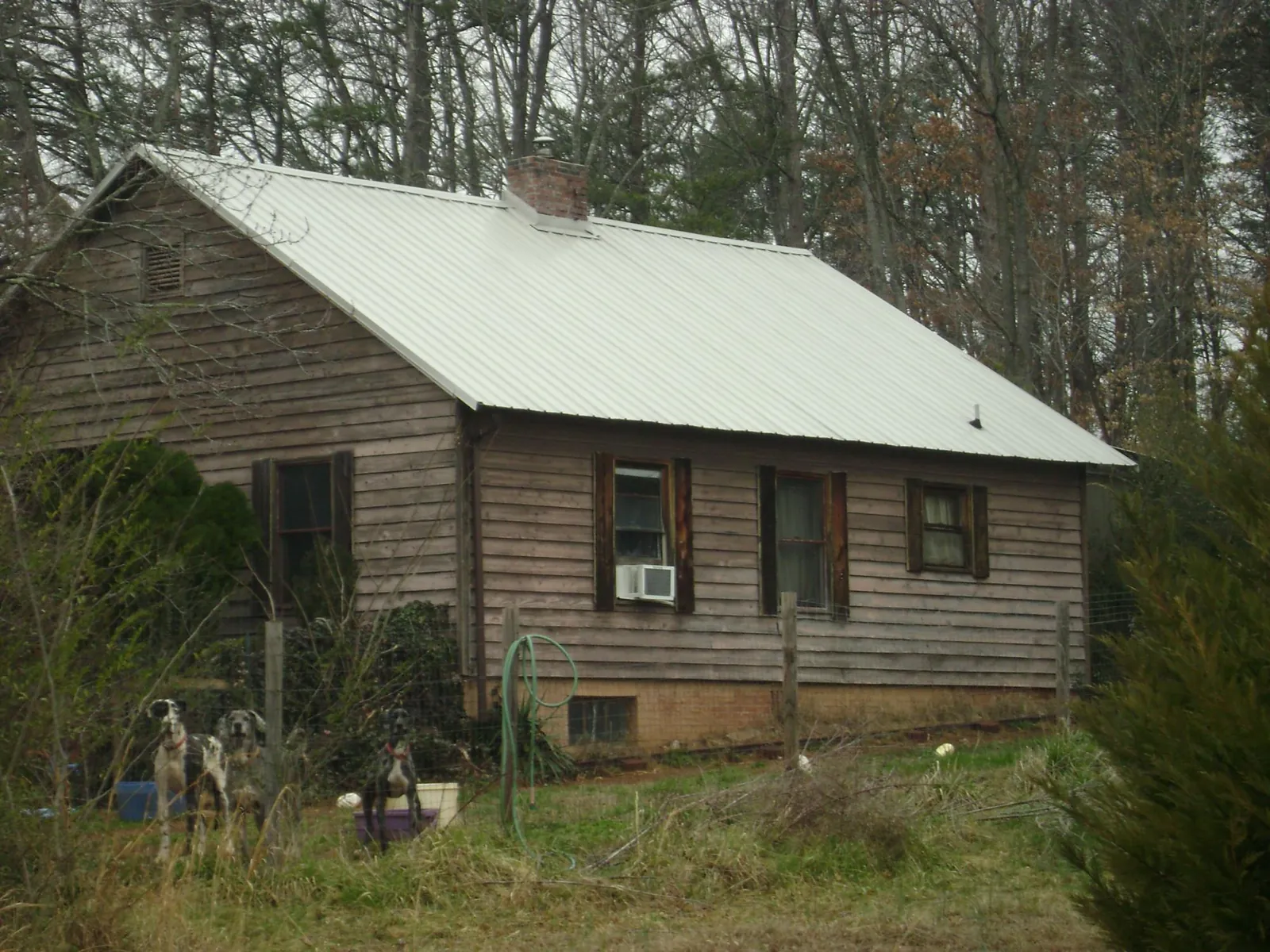 White metal roof on an old wood sided farmhouse, from a Metal Roof Installation job in Moyie Springs